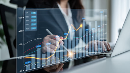 A business analyst engages with interactive financial data on a virtual screen, showcasing complex graphs and charts in a modern office setting, emphasizing analysis and insight.の写真素材