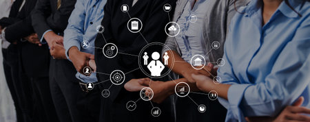 Professional group standing in a line with technology icons representing networking, digital communication, and team collaboration in a modern workspace setting.の写真素材