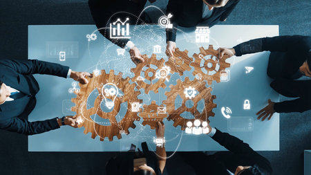 A top-view image of professionals engaged in a strategy meeting, utilizing gears and digital icons to symbolize collaboration, innovation, and effective teamwork in business. Rasterの写真素材
