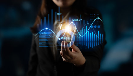A businesswoman stands confidently while holding a digital representation of financial data and graphs. The image captures the essence of modern analytics in today corporate world.の写真素材