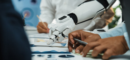 This image illustrates a unique collaboration between a robotic arm and human hands, highlighting the integration of technology in business analysis and strategic planning.Noogenesisの写真素材