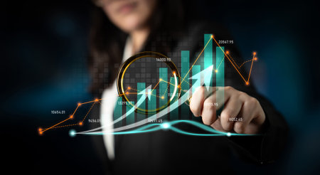 A businesswoman analyzes financial growth trends using advanced digital graphs and charts in a high-tech environment, highlighting the importance of data in corporate strategy.の写真素材