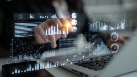 A business professional uses advanced digital tools to interact with data visualizations, enhancing...