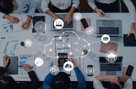 Aerial view of a modern office meeting showcasing cloud technology integration, digital devices, and...