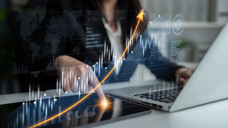 A business professional engages with data trends using a digital tablet while reviewing analytics on...
