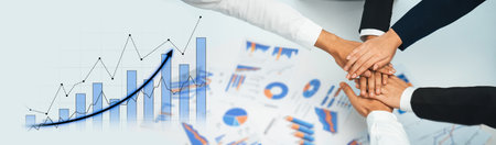 A diverse group of professionals joining hands in a symbol of teamwork, surrounded by graphs and...