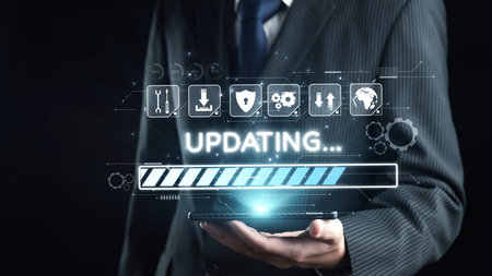 A businessman in formal attire holds a tablet displaying a digital progress bar with various technology icons. This image symbolizes data management and modern connectivity.の写真素材