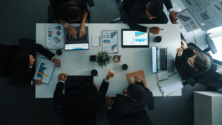Top down aerial view of smart businessman explain financial graph to investor while business team...