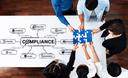 A diverse team collaborates to fit puzzle pieces representing compliance elements like governance,...