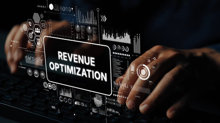 Hands Typing on Keyboard with Revenue Optimization Text and Digital Analytics Graphics in Background. Asymptotic smart data analytic.の写真素材