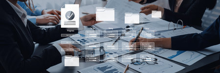 Business team investigating project data with charts, documents, and laptop in a modern office for successful strategy and performance analysis.の写真素材