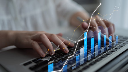A business professional engages with financial data on a laptop. The image shows charts and graphs...