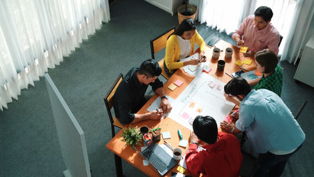 Top down view of diverse people brainstorming and making scrum task board. Group of skilled business...