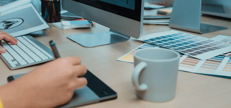 A professional creative workspace featuring a laptop, color palettes, and stationery, ideal for visual artists and designers seeking inspiration in their projects.の写真素材