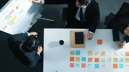 Top down aerial view of professional businessman find solution while brainstorm idea with executive manager by using sticky notes. Group of diverse start team share marketing strategy. Directorate.の写真素材