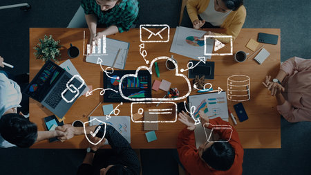 A diverse team collaborates in a modern office setting, surrounded by technology, charts, and...