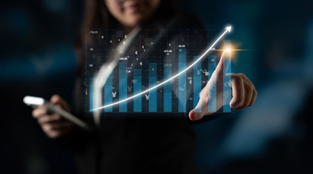 A business professional uses advanced technology to analyze financial data. The holographic display of charts signifies growth and success in a digital environment.の写真素材