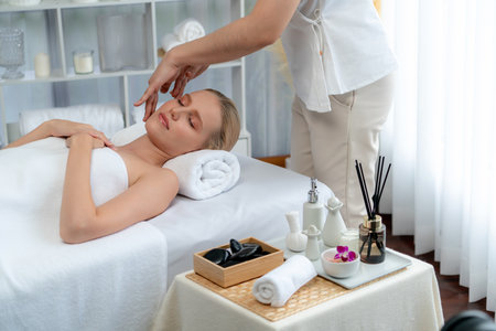 Caucasian woman enjoying relaxing anti-stress head massage and pampering facial beauty skin recreation leisure in dayspa modern light ambient at luxury resort or hotel spa salon. Quiescentの写真素材