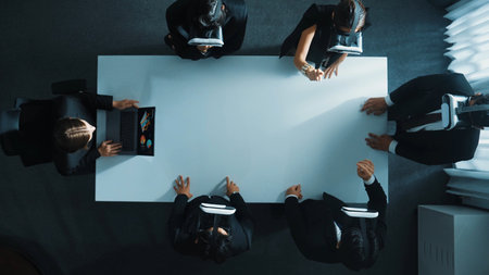 Top down aerial view of diverse data analysts wearing VR headset and stand around table while using hand gestures to manipulate the data streamed live from executive managers laptop. Directorate.の写真素材
