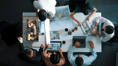 Top aerial view business people brainstorming about building interior at table with house model and...