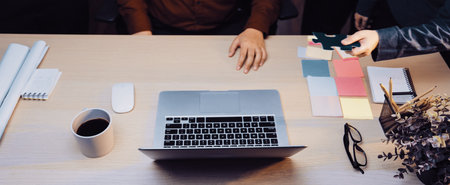 A vibrant scene of diverse professionals engaged in teamwork around a modern office desk, showcasing...