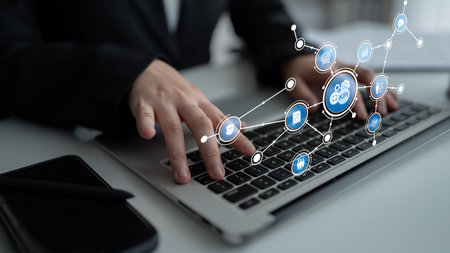 A business professional interacts with a laptop, showcasing digital icons that symbolize connectivity and technology in a modern workspace, enhancing productivity. Tesselの写真素材