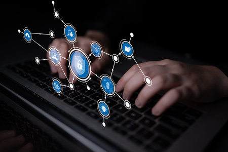 A close-up view of hands typing on a laptop keyboard, illustrated with digital security icons and...