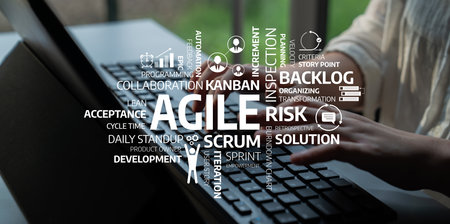 Hands typing on a laptop with an agile methodology word cloud showcasing essential concepts in software development, emphasizing teamwork, efficiency, and process improvements. Tesselの写真素材