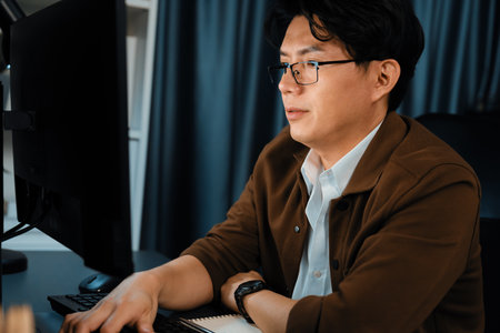 Smart businessman in casual day focusing computer to create business plan report over late night time at office, working on searching tools market planning with new startup company project. Infobahn.の写真素材