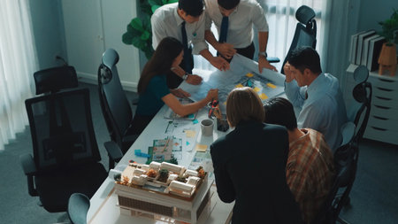 Group of diverse team planning strategy while sitting at table with project plan. Top aerial view of smart business people working together to brainstorm and design house construction.の写真素材