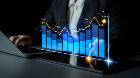 A business professional examines financial data displayed on a digital screen, showcasing a dynamic graph in a modern office setting with elegant lighting.の写真素材