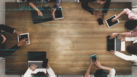 A modern office setting featuring a diverse team engaged in collaborative discussions, utilizing laptops and tablets for coding and innovative ideas.の写真素材