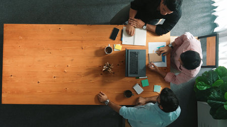 Top down aerial view of business team looking at financial graph while shaking hands for making agreement. Diverse people planning marketing strategy at table with stock market chart. Convocation.の写真素材