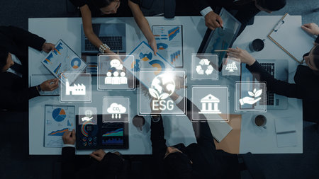 A dynamic meeting featuring diverse professionals analyzing data related to ESG practices. The focus is on sustainability and corporate responsibility in business strategies.の写真素材