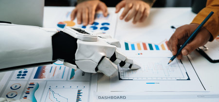 A futuristic robot arm assists professionals in analyzing data with various graphs and charts on a...