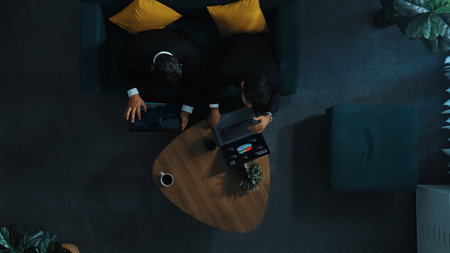 Top down aerial view of professional project manager walking to workspace and working on tablet while colleague holding laptop and support his performance. Business team working together. Directorate.の写真素材