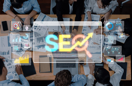 A dynamic business team engages in a strategy meeting focused on digital marketing trends, highlighting SEO with charts and analytics on a professional workspace.の写真素材