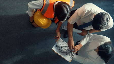 Top down view of smart architect engineer team looking at building design at meeting. Group of...