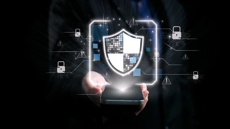 A person holding a smartphone displays a graphic of a digital shield, symbolizing the importance of data protection and cyber security in today technology-driven world.の写真素材