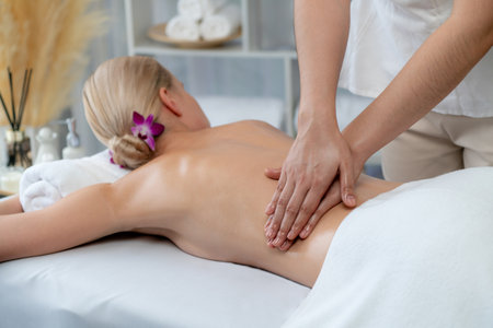 Caucasian woman customer enjoying relaxing anti-stress spa massage and pampering with beauty skin recreation leisure in day light ambient salon spa at luxury resort or hotel. Quiescentの写真素材