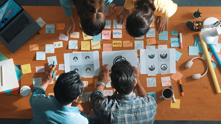Top view of business team write graphic logo on meeting table with colorful sticky notes and design while explain idea. Project manager sharing idea and explain concept art to smart team. Symposium.の写真素材