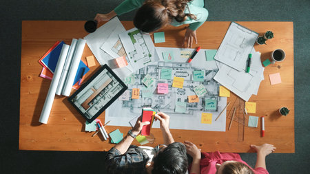 Top view of engineer working together to design building construction while standing at meeting table with blueprint and notes. Top view of interior designer choosing color from palettes. Symposium.の写真素材