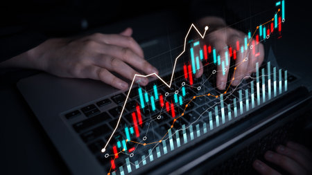 A close-up view of hands typing on a laptop with a modern financial chart overlay illustrating data trends and analytics for business and finance professionals.の写真素材