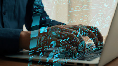A close-up view of hands typing on a laptop, layered with digital graphics representing data...