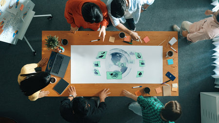 A diverse group of professionals engages in a collaborative meeting around a table featuring a world...