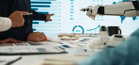 A modern meeting where human hands and a robotic arm collaborate to analyze data insights displayed on a high-tech screen, showcasing innovation and technology integration.の写真素材