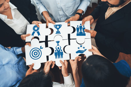 Engaging image depicting teamwork where diverse individuals unite puzzle pieces symbolizing success, goals, and collaboration in a professional business setting. Amityの写真素材