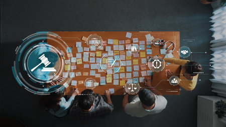 A team engaged in a strategic meeting focused on legal planning, surrounded by Post-it notes and digital icons, emphasizing teamwork and collaboration in a professional setting. Rasterの写真素材