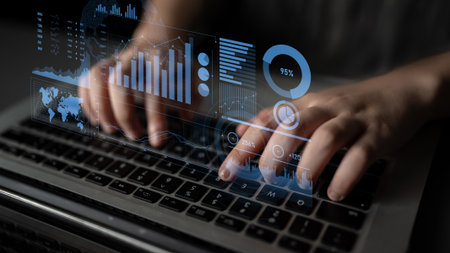 A person types on a laptop keyboard, immersed in data analysis while surrounded by virtual graphs...