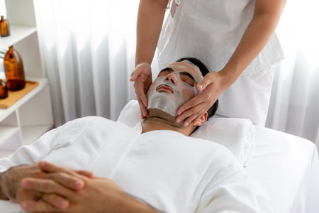 Serene modern daylight ambiance of spa salon, woman customer indulges in rejuvenating with facial skincare mask. Facial skin treatment and beauty cosmetology procedure for face. Quiescentの写真素材